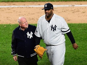 Head athletic trainer Steve Donohue walks CC Sabathia of the New York Yankees off the field during the eighth inning of game four of the American League Championship Series against the Houston Astros at Yankee Stadium on October 17, 2019 in the Bronx borough of New York City.