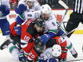 The Vancouver Canucks battle the Devils during second-period action at the Prudential Center on Oct.19 in Newark, N.J.