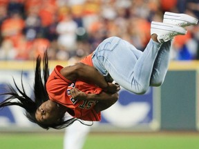 HOUSTON, TEXAS - OCTOBER 23:  Gymnast Simone Biles performs a flip after throwing out the ceremonial first pitch prior to Game Two of the 2019 World Series between the Houston Astros and the Washington Nationals at Minute Maid Park on October 23, 2019 in Houston, Texas.