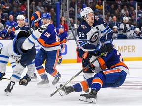 Mark Scheifele (55) and New York Islanders center Brock Nelson (29) collide during the second period at Nassau Veterans Memorial Coliseum on Sunday. Dennis Schneidler-USA TODAY Sports