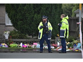 Armed police officers stand guard at a cordon blocking a road that leads to Linwood Mosque in Christchurch on March 17, 2019, two days after a shooting incident at two mosques in the city.