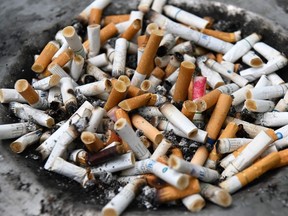 Cigarette butts are seen on a bin at a designated smoking area in Singapore on July 17, 2019.