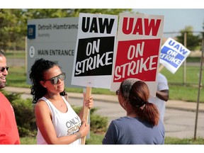 In this file photo taken on September 22, 2019 Coianne Abant, (L) a member of the United Auto Workers (UAW) Local 598 and supporters picket outside of General Motors Detroit-Hamtramck Assembly in Detroit, Michigan, as they strike on September 22, 2019.