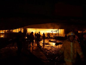 Firemen try to put out a fire on a mall following a 6.4-magnitude quake in General Santos City, in southern island of Mindanao, on Oct. 16, 2019. (EDWIN ESPEJO/AFP via Getty Images)