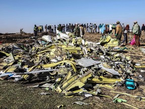 In this file photo taken on March 11, 2019, people stand near collected debris at the crash site of Ethiopia Airlines near Bishoftu, a town some 60 kilometres southeast of Addis Ababa, Ethiopia. (MICHAEL TEWELDE/AFP via Getty Images)