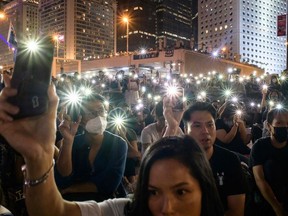 Attendees hold their mobile phones during a rally to show support for pro-democracy protesters in Hong Kong on October 19, 2019.