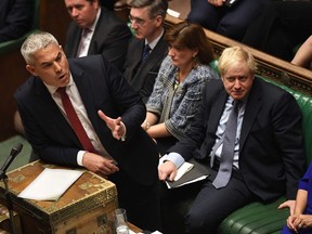 A handout picture released by the UK Parliament shows Britain's Secretary of State for Exiting the European Union (Brexit Minister) Stephen Barclay (L) speaking in the House of Commons in London on October 19, 2019, during a debate on the Brexit deal. - A day of high drama in parliament on Saturday saw lawmakers vote for a last-minute amendment to the deal that could force the government to seek to extend the October 31 deadline to leave. (Photo by JESSICA TAYLOR / UK PARLIAMENT / AFP) / RESTRICTED TO EDITORIAL USE - MANDATORY CREDIT " AFP PHOTO / UK PARLIAMENT / JESSICA TAYLOR  " - NO USE FOR ENTERTAINMENT, SATIRICAL, MARKETING OR ADVERTISING CAMPAIGNS - EDITORS NOTE THE IMAGE HAS BEEN DIGITALLY ALTERED AT SOURCE TO OBSCURE VISIBLE DOCUMENTS /