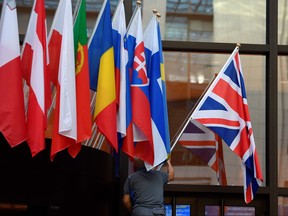 An employee hangs a Union Jack at the entrance of Consilium building at the  EU Headquarters in Brussels on Oct. 28, 2019. (JOHN THYS/AFP via Getty Images)