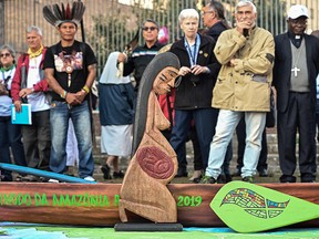 A wooden carved sculpture of a pregnant woman and a pirogue's model is pictured during a procession of indigenous leaders, prelates and people participating in the Special Assembly of the Synod of Bishops for the Pan-Amazon Region, on October 19, 2019 between Rome's Castel Sant'Angelo and the Vatican's St. Peters Square. (VINCENZO PINTO/AFP via Getty Images)