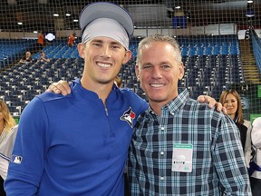In this May 24, 2019, file photo, Cavan Biggio of the Toronto Blue Jays poses with his father and Hall of Famer Craig Biggio at the Rogers Centre in Toronto.