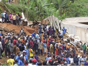 Rescue workers search through the rubble following a landslide in Bafoussam Cameroon, Tuesday, Oct. 29, 2019.