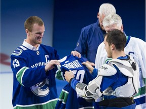 Vancouver Canucks former captain Henrik Sedin hands the captain's jersey to Bo Horvat at Rogers Arena, Vancouver, October 09 2019.