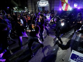 Catalan pro-independence demonstrators and riot police clash during a protest against police action, in Barcelona, Spain, Oct. 26, 2019.