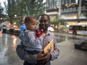 Alishia Liolli's husband Cialin Dany holds their child Evan, after attending a memorial service for Liolli, who died in Hurricane Dorian in the Bahamas, in Toronto on Oct. 1, 2019.