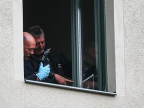 Forensic officers inspect a bullet hole in a window in front of the synagogue in Halle, Germany, October 11, 2019. (REUTERS/Hannibal Hanschke)