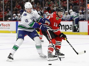 Elias Pettersson of the Vancouver Canucks and Alex DeBrincat of the Chicago Blackhawks battle for the puck at the United Center on March 18, 2019 in Chicago. (Jonathan Daniel/Getty Images)