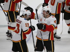 Calgary Flames left wing Johnny Gaudreau (13) is congratulated by defenseman Rasmus Andersson (4) after Gaudreau scored against the Dallas Stars during the shootout in an NHL hockey game in Dallas, Thursday. The Flames won 3-2. Photo by Michael Ainsworth/AP.