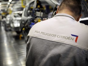 An employee is working on the assembly line of the French car maker group PSA Peugeot Citroën, on November 5, 2008 at the Sochaux factory, central France.