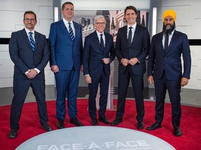From left to right, Leader of the Bloc Quebecois Yves-Francois Blanchet, Leader of the Conservative Party of Canada Andrew Scheer, Canadian journalist Pierre Bruneau, Leader of the Liberal Party of Canada Justin Trudeau and Leader of the New Democratic Party Jagmeet Singh pose for pictures ahead of the French debate for the 2019 federal election, the "Face-a-Face 2019" presented in the TVA studios, in Montreal, on Wednesday, Oct. 2, 2019.