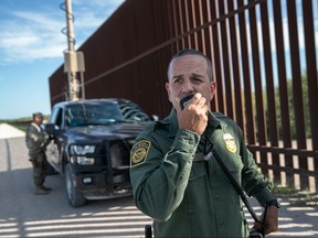 U.S. Border Patrol agent Carlos Ruiz spots a pair of undocumented immigrants while coordinating with active duty U.S. Army soldiers near the U.S.-Mexico border fence on September 10, 2019 in Penitas, Texas.