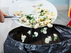 Person Throwing Cooked Pasta In Trash Bin