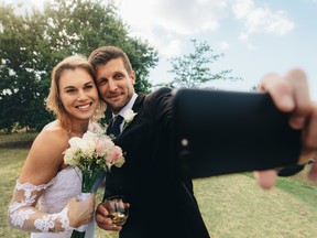 A bride and a groom are pictured taking a selfie in this file photo. (Getty Images file photo)