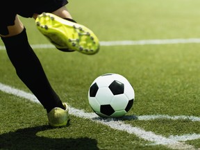 Foot of a child football player and ball on the football field