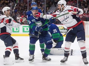 Washington Capitals' Tom Wilson, right, punches Vancouver Canucks' Tanner Pearson, centre, after the whistle during the first period in Vancouver, on Friday October 25, 2019.