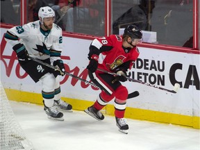 Sharks winger Barclay Goodrow, left, chases Senators forward Filip Chlapik along the boards during the third period of Sunday's game.