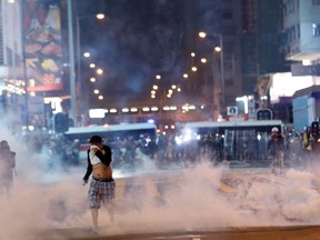 A man runs among the tear gas during a protest in Hong Kong's tourism district of Tsim Sha Tsui, China October 27, 2019.