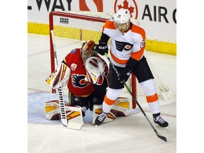 Flames goalie David Rittich battles with Flyers forward James van Riemsdyk in first period NHL action at the Scotiabank Saddledome in Calgary on Tuesday, Oct. 15, 2019.