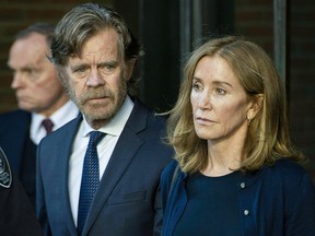 In this file photo taken on September 13, 2019 actress Felicity Huffman, escorted by her husband William H. Macy, exits the John Joseph Moakley United States Courthouse in Boston. (JOSEPH PREZIOSO/AFP via Getty Images)