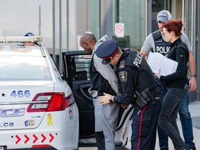Muzamiro Semitego, 31, aka Jean-Jeffrey Badiau, one of 31 charged in the multi-provincial human trafficking probe Project Convalesce is escorted to a cruiser by officers. (supplied by York Regional Police)