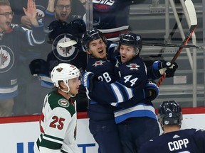 Jets’ Jack Roslovic (left) celebrates his third-period goal against the Minnesota Wild on Thursday night alongside teammate Josh Morrissey. The Jets have three wins in five games and take on the Blackhawks in Chicago on Saturday. (KEVIN KING/WINNIPEG SUN)