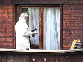 A forensic expert collects evidences on the balcony of a house in Kitzbuehel, Austria, where five people were killed on October 6, 2019. (ZEITUNGSFOTO.AT/AFP via Getty Images)
