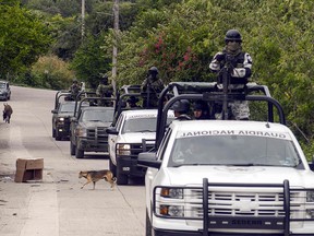 Members of Mexico's National Guard drive by the site where a confrontation between the Mexican Army and armed civilians took place in Tepochica, Mexico, on October 16, 2019. (FRANCISCO ROBLES/AFP via Getty Images)