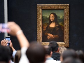 Visitors take pictures in front of Mona Lisa after it was returned at its place at the Louvre Museum in Paris on Oct. 7, 2019.