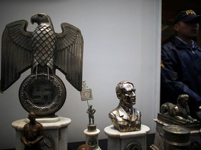 A police officer stands next to Nazi artifacts during a news conference at the Holocaust Museum in Buenos Aires, Argentina October 2, 2019. (REUTERS/Agustin Marcarian)