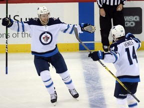 Jets defenxeman Neal Pionk (left) celebrates a goal against the Devils during the third period at Prudential Center in Newark, N.J., on Friday, Oct. 4, 2019.