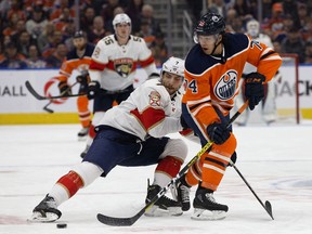 The Edmonton Oilers' Ethan Bear battles the Florida Panthers' Colton Sceviour during first period NHL action at Rogers Place, in Edmonton Sunday Oct. 27, 2019.