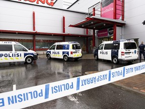 Police vans are seen in front of the Herman shopping centre where the Savo Vocational College is located in Kuopio, Finland, Oct. 1, 2019.