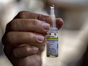 A community health worker shows a vial of an oral polio vaccine, during a mass vaccination campaign to combat the resurgence of the polio virus, at a slum area on October 14, 2019 in Manila. (Ezra Acayan/Getty Images)