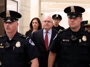 Philip Reeker, acting assistant secretary of state for European and Eurasian Affairs, is escorted by police officers as he leaves after testifying in impeachment inquiry against U.S. President Donald Trump, in Washington D.C., Oct. 26, 2019.
