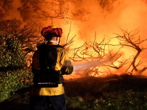 Firefighters battle a wind-driven wildfire called the Saddleridge Fire in Porter Ranch, Calif., in the early morning hours of Friday,  Oct. 11, 2019.