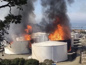 In this image from video provided by the Napa County Sheriff's Office, tanks are on fire at an oil storage facility Tuesday, Oct. 15, 2019, viewed from Rodeo, Calif. (Henry Wofford/Napa County Sheriff's Office via AP)