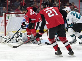 San Jose Sharks goalie Aaron Dell makes a save on Ottawa Senators left wing Brady Tkatchuk on Sunday night at the Canadian Tire Centre.