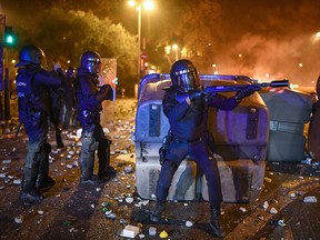 Armed police officers stand in front of protesters as objects are thrown during a protest over the jail sentences given to separatist politicians by Spains Supreme Court, on October 18, 2019 in Barcelona, Spain. (Jeff J Mitchell/Getty Images)