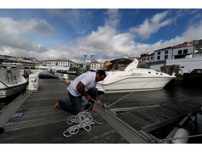 A man reinforces with ropes the mooring of his boat at a port before the arrival of Hurricane Lorenzo in Angra do Heroismo in the Azores islands, Portugal October 1, 2019.