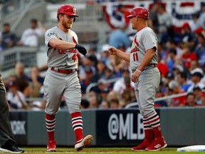 Cardinals' Harrison Bader, left, is congratulated by first base coach Stubby Clapp after hitting an infield single against the Braves during the fifth inning in Game 1 of the National League Division Series at SunTrust Park in Atlanta, on Friday, Oct. 3, 2019.