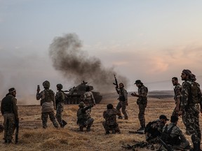 In this file photo taken on October 14, 2019 Turkish soldiers and Turkey-backed Syrian fighters gather on the northern outskirts of the Syrian city of Manbij. ( ZEIN AL RIFAI/AFP via Getty Images)